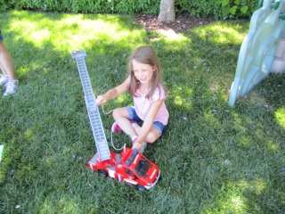 Camryn playing with the firetruck spraying water